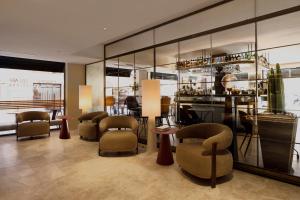 a lobby with chairs and tables and mirrors at Aparthotel Mariano Cubi Barcelona in Barcelona