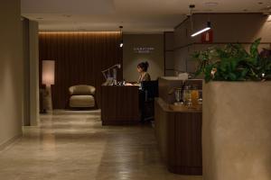 a woman sitting at a desk in a hotel lobby at Aparthotel Mariano Cubi Barcelona in Barcelona