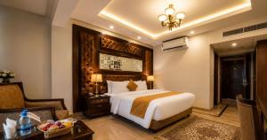 a bedroom with a bed and a desk and a chair at Envoy Continental Hotel, Blue Area, Islamabad in Islamabad