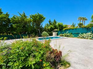 a swimming pool in a garden with flowers at Casa el Jilguero Conil in Conil de la Frontera