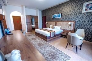 a hotel room with a bed and a desk and chair at Al Diyar Hotel in Nizwa +23 photos