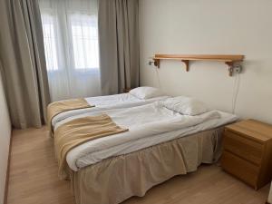 a bedroom with two beds and a shelf on the wall at Åhus Havsvillor in Åhus