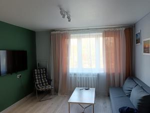 a living room with a couch and a table and a window at Sea&Sun in Liepāja
