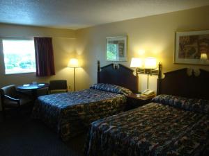 a hotel room with two beds and a table at Wilmington Inn in Wilmington +20 photos