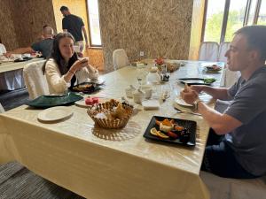 a man and woman sitting at a table eating food at Muras in Bokonbayevo +15 photos