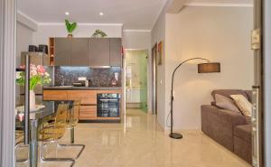 a living room and kitchen with a couch and a table at Irene Luxury Suite Roda in Roda
