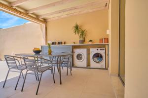 a dining room with a table and a washing machine at Irene Luxury Suite Roda in Roda