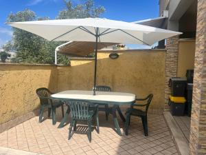 a table and chairs with an umbrella on a patio at La Cha di Giada in Anzio