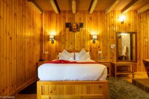 a bedroom with a bed in a wooden room at Phuntsho Guest House in Jakar +3 photos