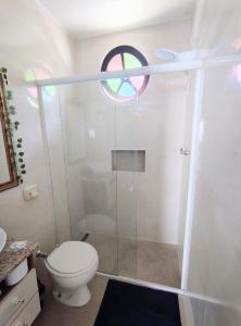 a bathroom with a shower with a toilet and a window at Apartamento Canasvieiras in Florianópolis +14 photos