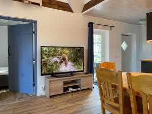 a living room with a flat screen tv on a stand at Charmig stuga i Abbekås in Abbekås