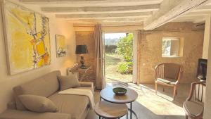 a living room with a couch and a table at Le Refuge in Denicé