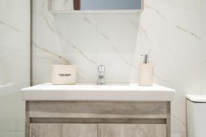 a bathroom with a white sink and a mirror at Meraki luxury bungalows in Rakhónion +29 photos