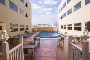 an outdoor patio with a pool and tables and chairs at Al Diyar Hotel in Nizwa