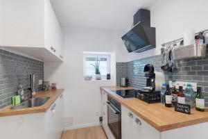 a white kitchen with a sink and a counter top at Ferienwohnung Tromei-Hof in Oberderdingen