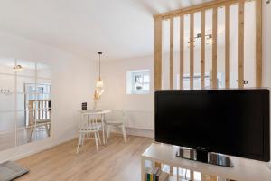 a living room with a flat screen tv on a table at Ferienwohnung Tromei-Hof in Oberderdingen