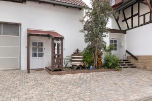 a white house with a door and a porch at Ferienwohnung Tromei-Hof in Oberderdingen