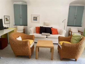 a living room with two chairs and a couch at Oliveto Sleeps 4 with Private Garden in Castelbianco