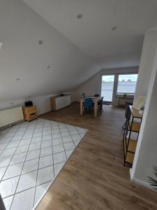 an empty living room with a table and a large window at FeWo Weitblick in Sassenburg