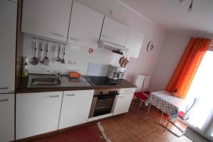 a kitchen with white cabinets and a sink at Ferienhaus B2 Concordiasee in Friedrichsaue