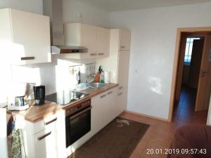 a kitchen with white cabinets and a sink at Ferienhaus B2 Concordiasee in Friedrichsaue