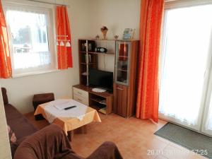 a living room with a couch and a tv at Ferienhaus B2 Concordiasee in Friedrichsaue