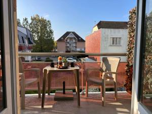 a patio with a table and chairs on a balcony at Studio de vacances Stella Plage in Cucq