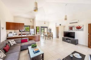 a living room with a couch and a table at Villa Sea Side in Polis Chrysochous