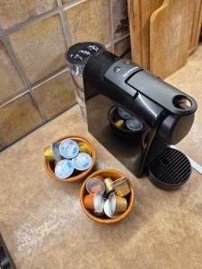 a coffee machine sitting on a counter with bowls of coins at Apartment Rustico in Ancient Epidauros