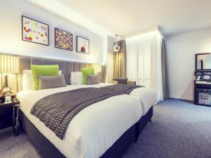 a bedroom with a large bed with green accents at Mercure London Paddington Hotel in London +90 photos