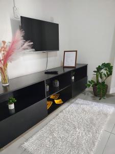 a black entertainment center with a flat screen tv at Apartamento Canasvieiras in Florianópolis