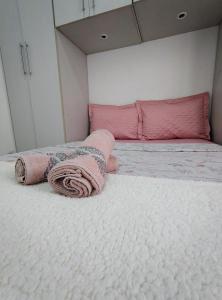 a bedroom with a bed with pink blankets on it at Apartamento Canasvieiras in Florianópolis