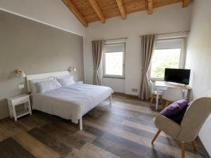 a bedroom with a bed and a desk and a computer at B&B La Piccola Lepre in Acqui Terme