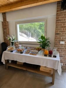 a table with food on it in a room with a window at B&B La Piccola Lepre in Acqui Terme