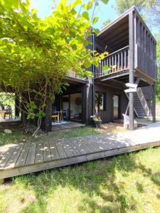 a house with a wooden deck and a tree at Eco-lodges Lacanau Moutchic Inn - 4 pers in Lacanau
