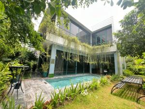 an external view of a house with a swimming pool at FLAMINGOS VENUS REORT -Xanh Villa - 4 phòng ngủ- Bể bơi riêng-Free vé cổng in Phúc Yên