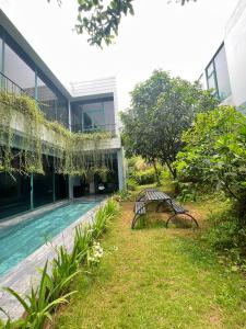 a bench next to a building with a swimming pool at FLAMINGOS VENUS REORT -Xanh Villa - 4 phòng ngủ- Bể bơi riêng-Free vé cổng in Phúc Yên