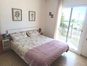 a bedroom with a bed and a large window at Seafront Sitges in Sitges