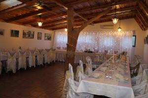 a banquet hall with white tables and white chairs at Penzión U Tonky in Tomek