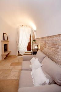 a living room with a couch and a brick wall at Antica casa Scesciola in Rutigliano