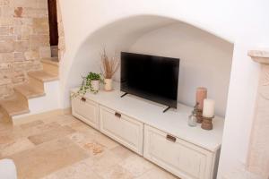 a flat screen tv sitting on top of a white cabinet at Antica casa Scesciola in Rutigliano