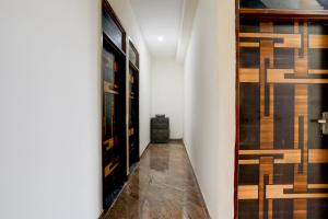 a hallway with wooden floors and a wall with paintings at Hotel O Kalka in Faridabad