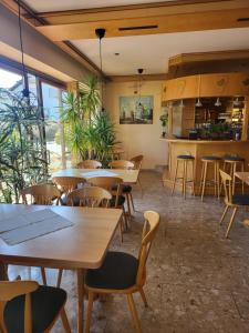 a restaurant with wooden tables and chairs and windows at Hotel Seerose Garni in Nohfelden