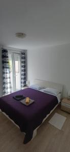 a bedroom with a large bed with a purple blanket at Fazana SS in Fažana