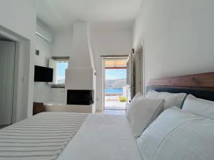 a white bedroom with a large bed and a window at Gaia & Thalassa Villa Nafsika in Otziás +32 photos