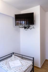 a bedroom with a bed with a tv on the wall at Motel Ketmia in Plecka Dąbrowa