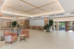 a lobby with chairs and tables in a building at Aquasol Aparthotel in Palmanova +38 photos