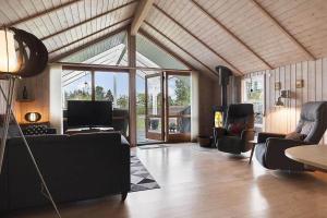 a living room with a couch and chairs and a tv at HA411-Hals-Junovej-13 in Hals