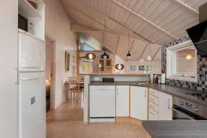a kitchen with a white refrigerator and a table at HA411-Hals-Junovej-13 in Hals