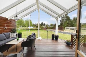 a wooden deck with a pergola with a couch and a table at HA411-Hals-Junovej-13 in Hals